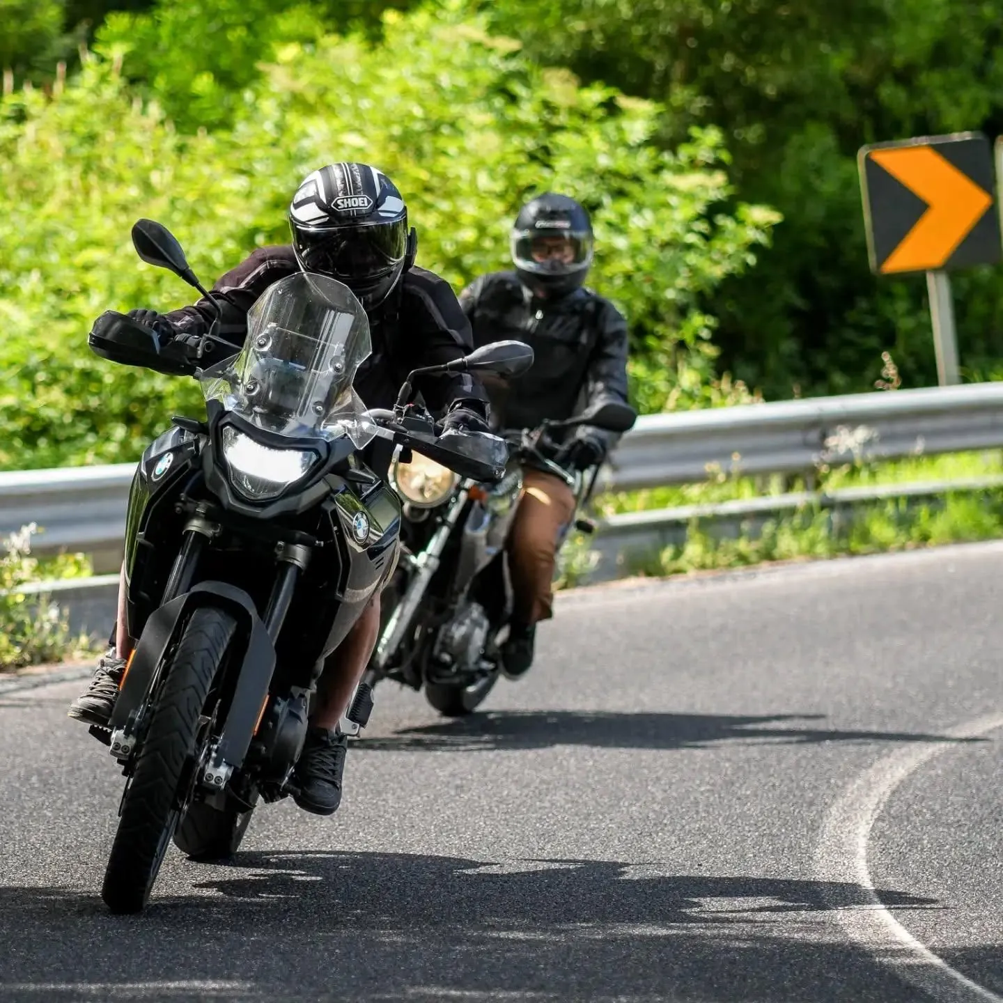 Duas motas a fazer uma curva em estrada de montanha