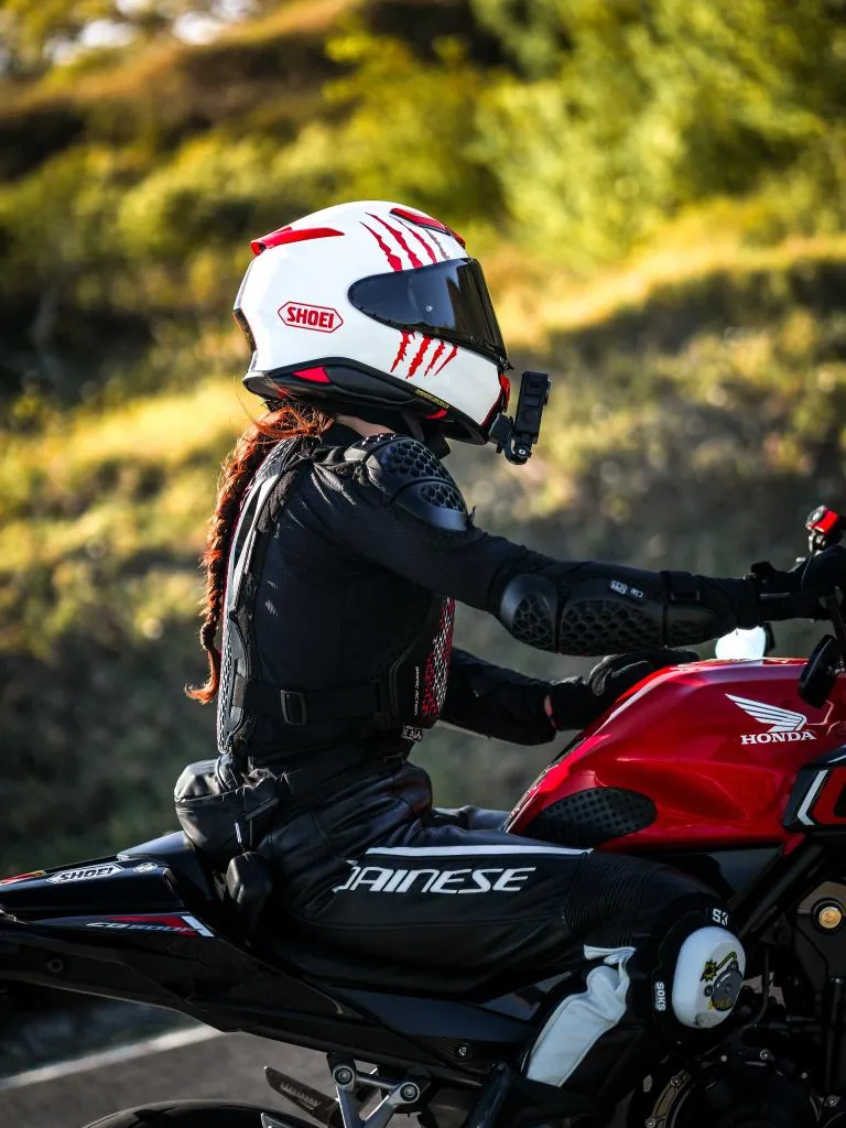 Piloto de capacete branco numa Honda vermelha