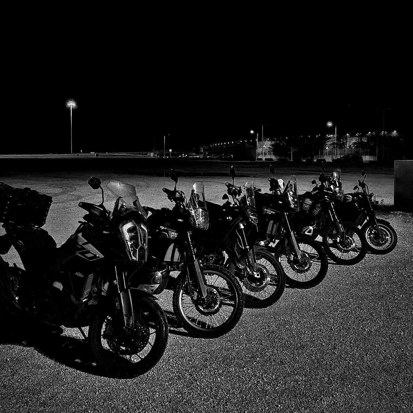 Fila de motas de aventura estacionadas à noite