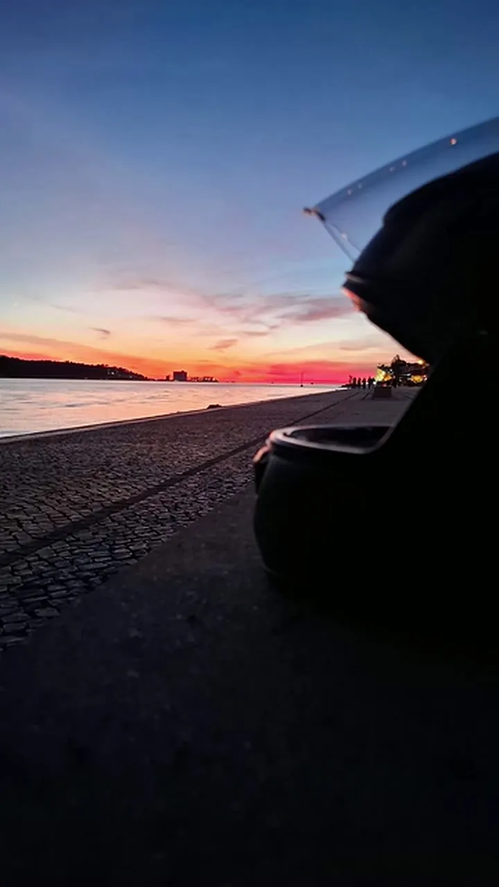 Pôr-do-sol no Tejo visto ao nível do chão, com um capacete